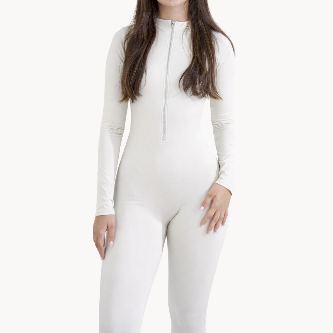Macaquinho full body branco ELLEVE com mangas longas e zíper frontal, efeito segunda pele e modelagem ajustada. Tecido elástico e respirável para conforto no dia a dia ou treino. Design minimalista e versátil. ELLEVE, USELLEVE, USELLEVE.COM